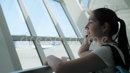 年轻女子正在飞行区机场候机楼用手机交谈。视频