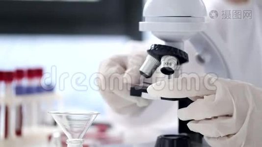 穿着全套衣服的科学家正在现代实验室里调整显微镜视频