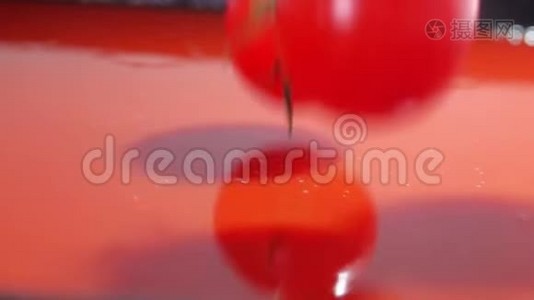 超级慢动作特写镜头，红色成熟番茄落在红色果汁或酱汁中视频