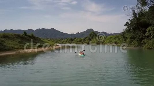 独木舟上的观光客在大河中靠近树木航行视频