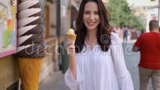 美丽的黑发女人吃美味可口的冰淇淋视频