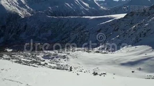 冬天的时候，人们在雪山上滑雪。 晴朗的一天，有蓝天的景观滑雪道。 Pirin山峰，风景如画视频