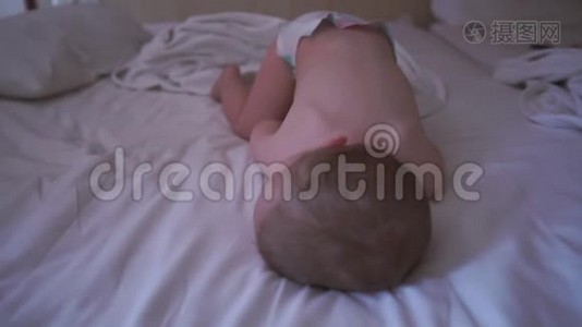一个穿着尿布的裸体小男孩正在床上缓慢地睡觉视频