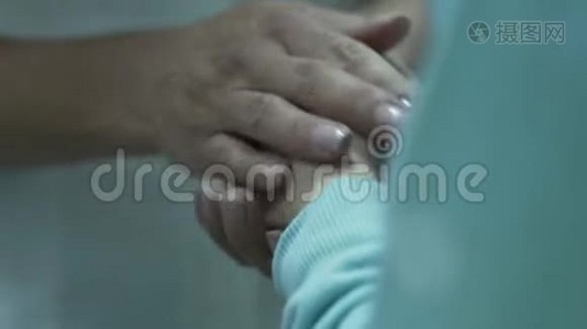 不认识的女医生按摩小病人的手，安抚孩子。 保健、治疗概念视频