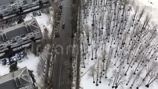 直升机飞过道路和灰色的房子与冰冻的湖视频