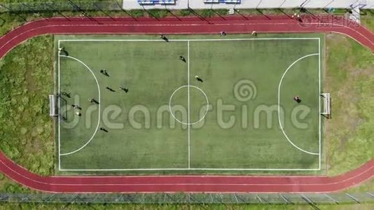 顶部的空中景观。 孩子们通过在一个小足球场上踢足球来进球。视频