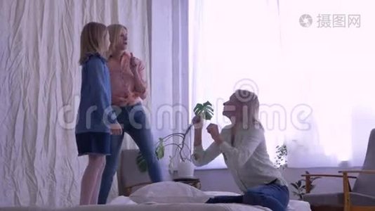 母子关系，快乐的女孩在家门口站在床上唱歌跳舞视频