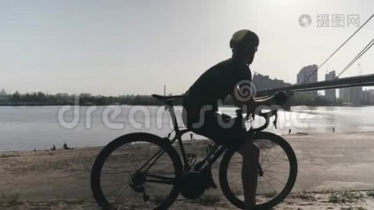 专业瘦身骑自行车的骑自行车的人看着河上的一座桥，车通过。 Cyclist做梦和思考视频