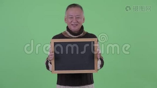 快乐成熟的日本男人拿着黑板说话视频