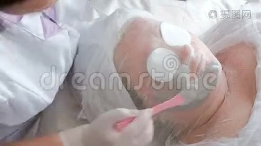 医学美容程序。 加速视频：美容师的手把海藻酸钠面膜强加在女人的脸上。 皮肤c视频