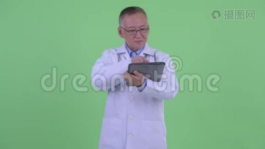 快乐成熟的日本男医生用数码平板电脑思考视频