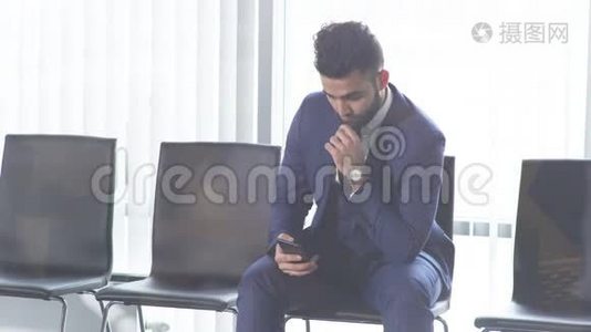 穿着时尚西装坐在智能手机旁的寂寞帅哥视频