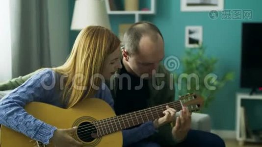 他教女孩在客厅弹吉他视频