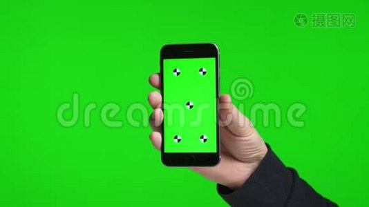 男人`手握着一个绿色的手机屏幕视频