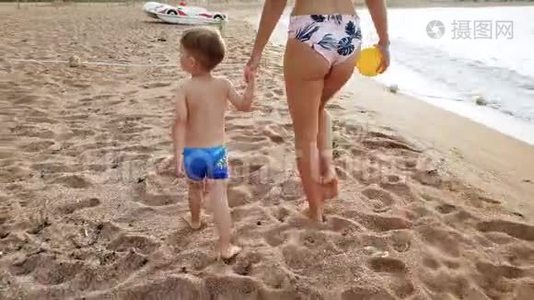4k视频美丽的年轻女子与她的3岁孩子男孩在海滩上散步日落视频