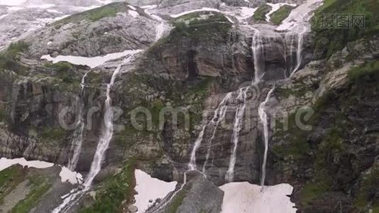 空中观景无人机拍摄到几条瀑布从陡峭的大山岩上流下来，这些岩石被郁郁葱葱地包围着视频