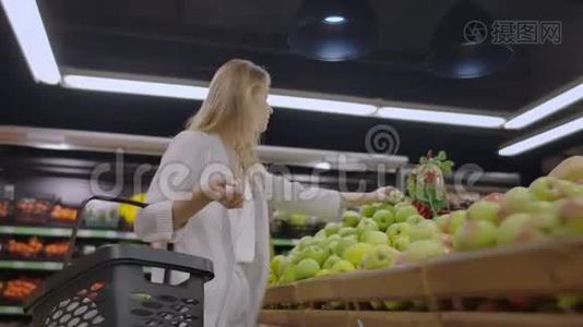 有魅力的年轻女性在水果蔬菜超市市场选择苹果。视频