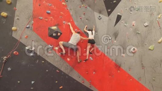 年轻女子在攀岩墙上取得了成功。视频