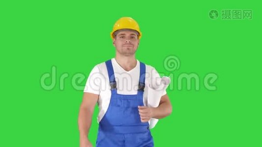 建筑工人带着蓝色的指纹走着，微笑着在绿色屏幕上拍摄，Chroma键。视频