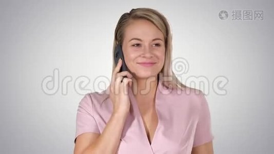 笑的金发女商人在梯度背景下有一个有趣的电话交谈。视频