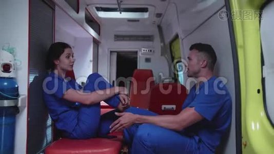 医护人员坐在救护车里，谈笑风生。视频