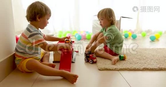 幼儿坐在地板上玩玩具车视频