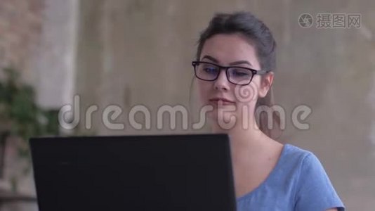 在家庭教育特写中，戴眼镜的现代女孩看着笔记本电脑屏幕，在键盘上输入文字视频