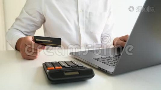 Hands持有信用卡并在家庭办公室使用笔记本电脑的4k视频、支付和网上购物概念视频