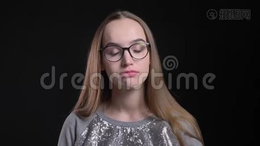 戴眼镜的年轻迷人的时髦女郎的特写镜头，使孩子气、可爱、悲伤的面部表情看上去很可爱视频