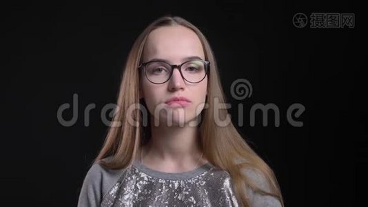 年轻迷人的戴眼镜的时髦女性特写镜头，困惑而体贴地直视镜头视频