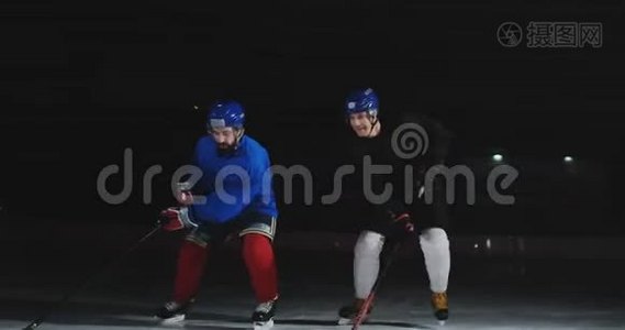 两个人在溜冰场打曲棍球。 两个冰球运动员为冰球而战。 史泰康视频
