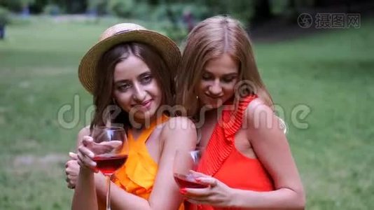 两个金发女孩坐在公园里喝着酒视频