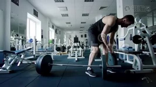 年轻的运动员在健身房锻炼前，要把体重放在杠铃酒吧视频