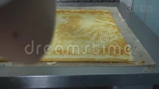 糖果师把奶油放在饼干卷上。 蛋糕烘焙产品。 手工制作带有焦糖或视频