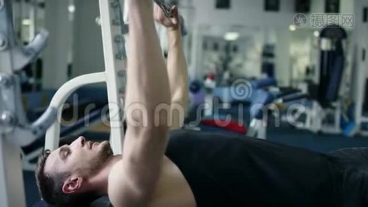 健身室里躺在长凳上锻炼杠铃的成年运动员视频