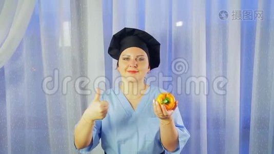 一位女厨师微笑着，手里拿着一根黄椒，向全班同学展示视频