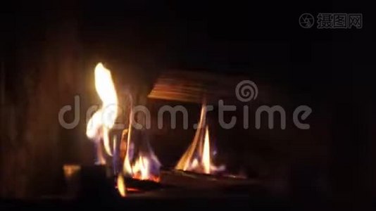 在舒适的砖制壁炉中，用橙色火焰缓慢燃烧的木头上拍摄了非常令人满意的特写镜头视频