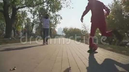这个男孩正在骑滑板车。 孩子正跑在公园里踢红球视频