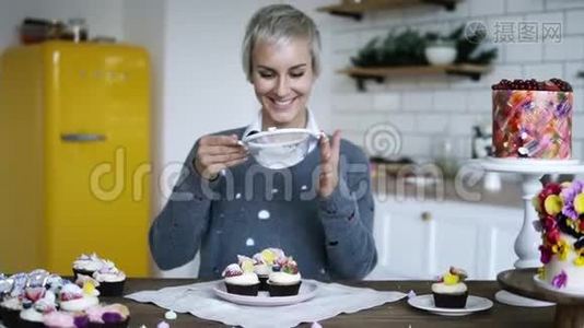 年轻女性糖果装饰美味，花哨装饰的纸杯蛋糕。 带着灰色头发糖霜的女人视频
