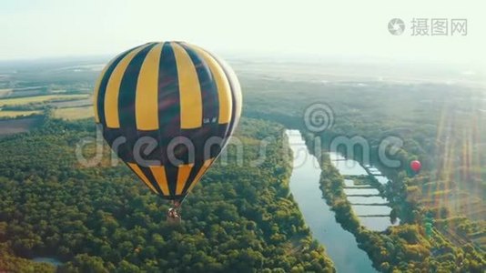 蓝色天空中的黄色热气球。 气球飞过树木。 美丽浪漫夏日视频