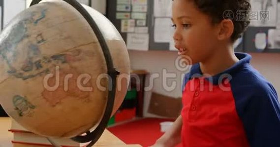 非裔美国小学生4k教室课桌学习地球仪的侧视图视频