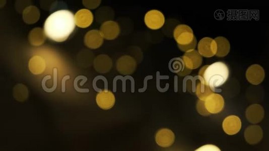 模糊的黄色圣诞波克照明在离焦。 抽象粒子背景视频