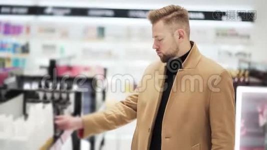 年轻的帅哥在化妆品店挑选商品，购物理念视频