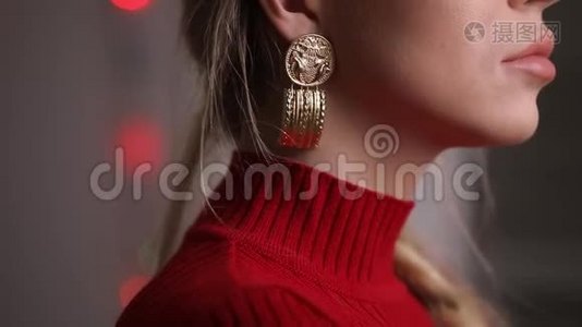 时尚漂亮的红裙模特摆着触摸耳环，珠宝概念视频