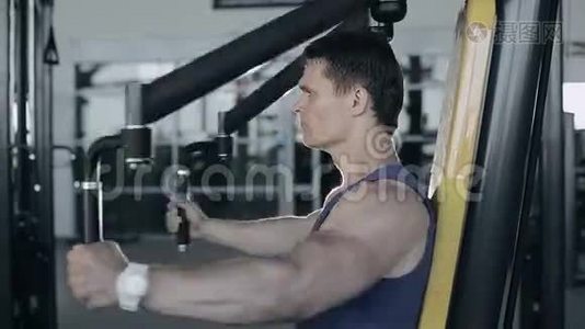 肌肉健美运动员在健身房锻炼乳房肌肉。正面拍摄视频
