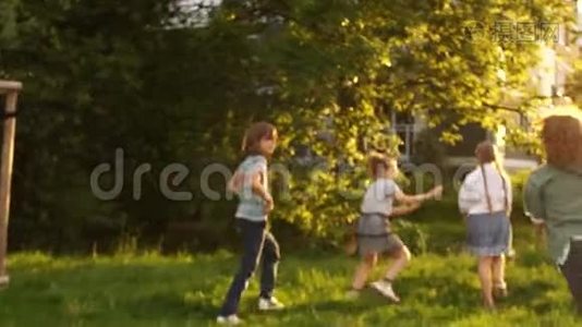 一群孩子在城市公园里玩耍。 夕阳的光辉，快乐的童年理念，孩子们`游戏视频