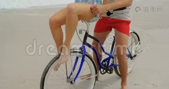 高加索夫妇在海滩上骑自行车的正面景色视频