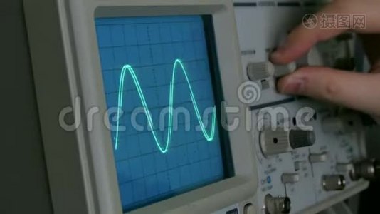 示波器上的振幅图.. 一个人按下设备上的按钮。 几何线改变形状视频