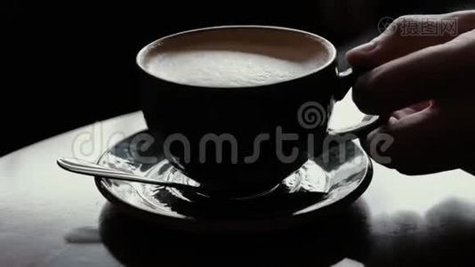 特写男人的手从咖啡馆的桌子上拿咖啡，把它放回茶托上视频
