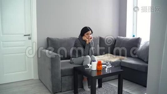 悲伤的单身女人坐在沙发上，面前有很多药丸。视频